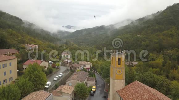 在一个被云层覆盖的群山环绕的山村的高角度景观4k视频的预览图
