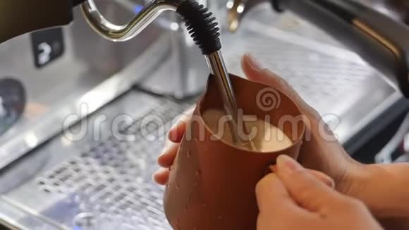 专业咖啡师制作新鲜的磨碎咖啡咖啡师制作拿铁艺术在制作过程中将牛奶倒入杯子视频的预览图