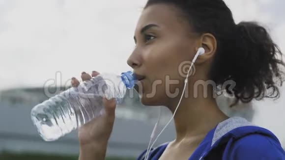 非洲裔美国少女晴天在公园新鲜空气中跑步后喝冷水视频的预览图