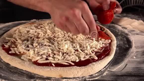 厨师手在披萨上铺上美味的腊肠带有番茄酱和磨碎奶酪的披萨快速的概念视频的预览图