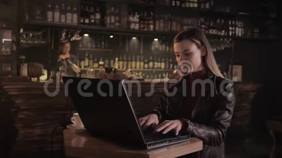 一位成功的女企业家坐在时尚酒吧的桌子旁一边在电脑前工作一边把胳膊搭在胸前视频的预览图