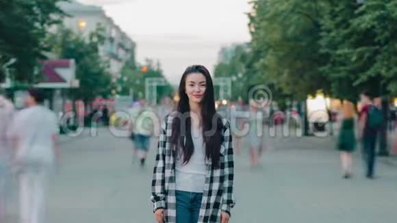 年轻女士微笑着站在城市街道上的时光流逝画像视频的预览图
