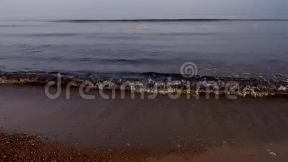 浪冲向沙岸清晨的薄雾视频的预览图