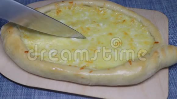 一块自制的卡沙普里格鲁吉亚奶酪糕点用刀子切视频的预览图