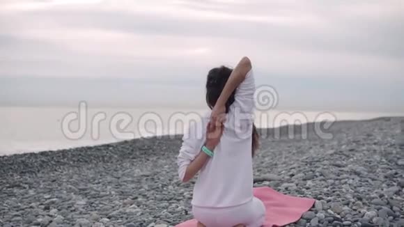女人在海滩上伸展手臂视频的预览图