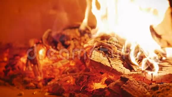 烧焦的木头在披萨炉里燃烧得非常完美用比萨饼皮把比萨饼放在木烧的比萨饼烤箱里视频的预览图