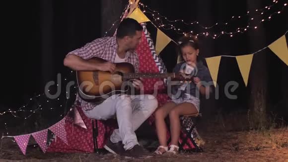 亲戚之间的关系为父亲和母亲在树林里玩吉他而高兴视频的预览图