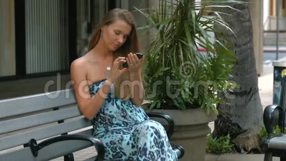 年轻的白人女性在城市短信手机视频的预览图