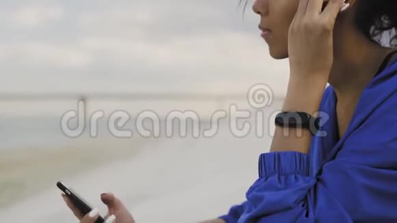 非洲裔美国跑步妇女带着耳机和智能手表在公园跑步后休息视频的预览图