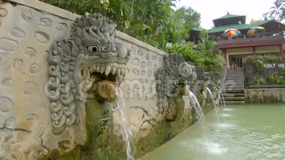 在巴厘岛著名的班贾尔温泉里从龙的嘴里流出的瀑布巴厘旅行概念视频的预览图