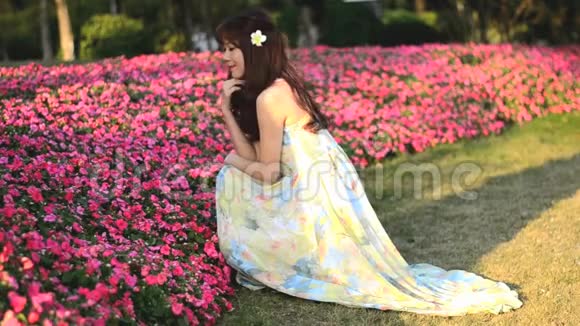 美丽的亚洲女孩穿着长裙在花园里玩耍视频的预览图