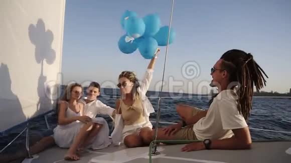 四个朋友在游艇上放松巡航同时躺在船头他们享受这一刻一个女孩视频的预览图