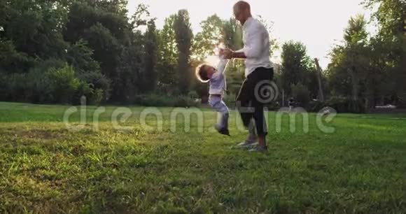 微笑和快乐的爸爸和他的小儿子在公园里玩得很可爱日落时分一起享受这一刻视频的预览图