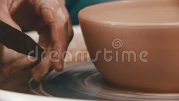 陶器主人正在用一种特殊的造型工具帮助自己去除多余的粘土视频的预览图