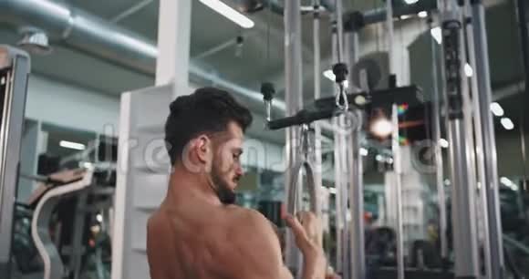 一个身材集中的人在健身房锻炼身体为他的二头肌和三头肌举重视频的预览图