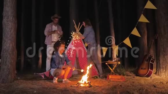 露营美丽的妻子和她快乐的丈夫在森林里放松后搭起了帐篷而小女儿则炸薯条视频的预览图