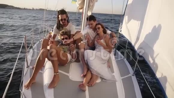 一群年轻快乐的朋友或两对夫妇在夏天乘游艇船头航行朋友男人和女人在那里放松视频的预览图