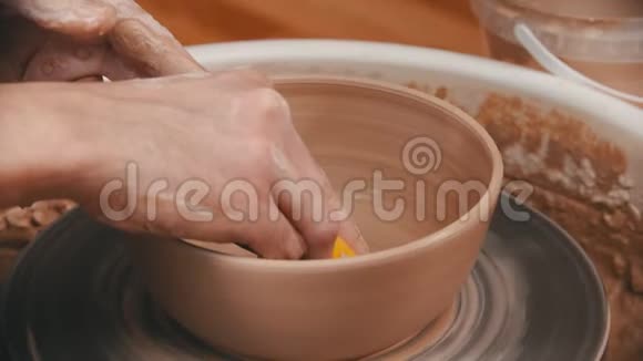 陶器师傅正在用黄色海绵擦碗底视频的预览图