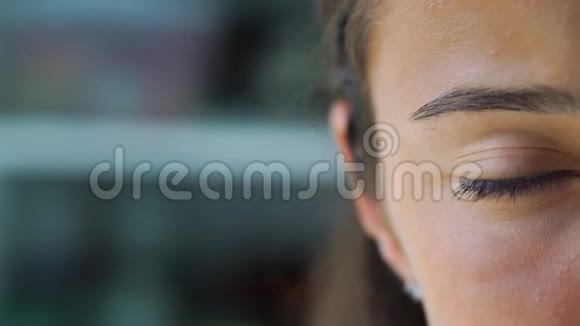 少女棕色眼睛在模糊的背景上眨眼视频的预览图
