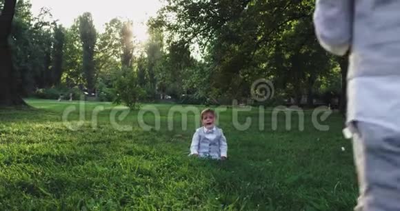 两个穿西装的小男孩一起在草地上玩公园里有个球小男孩开始哭了视频的预览图