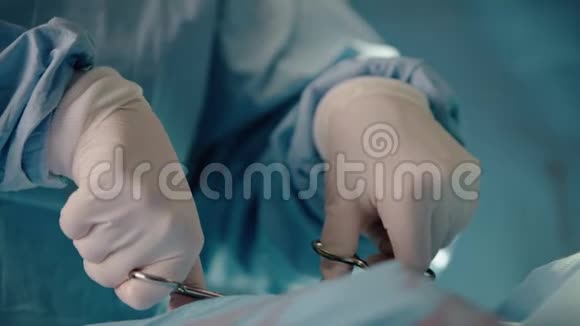 外科医生操作手把手里的外科医生手术刀合上护士把手术刀交给外科医生医疗队视频的预览图