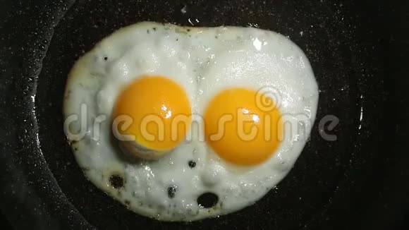 煎蛋的过程炸鸡蛋在煎锅里煎两个鸡蛋的煎蛋视频的预览图