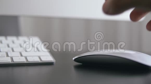 在办公室里一个拿着电脑鼠标在电脑上工作的人的特写镜头视频的预览图
