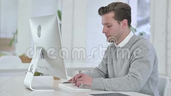 年轻人在桌面上工作做大拇指视频的预览图