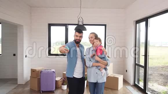 年轻的一家人刚搬进一个新家爸爸在一个新家里自拍他的家人视频的预览图