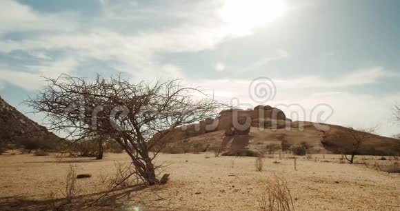 沙漠有小的干燥植物和大的岩石山背景纳米比亚4k视频的预览图