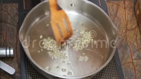 厨师在餐厅用橄榄油煎大蒜视频的预览图