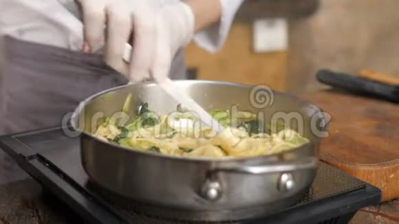 厨师在餐厅厨房的平底锅里煮意大利面视频的预览图