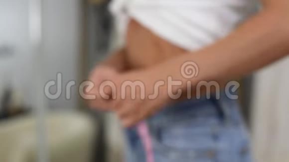 穿牛仔裤的背景模糊的女人减肥后的腰围视频的预览图