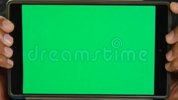 一个男人拿着一个绿色屏幕的平板电脑一个变色的平板电脑视频的预览图