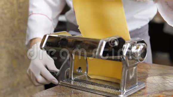 厨师的手使用意大利面切割机从意大利面机出来的新鲜意大利面视频的预览图