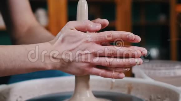 陶器工艺一个人的手形成一块较长形状的粘土在陶工的车轮上旋转视频的预览图