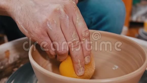 一个用海绵做陶工的泥人除去剩菜视频的预览图