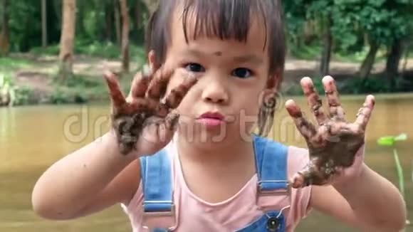 快乐的小女孩在夏天用脏手视频的预览图