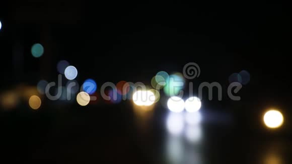 彩色散焦夜路灯与反射背景城市交通中移动汽车的离焦前灯视频的预览图