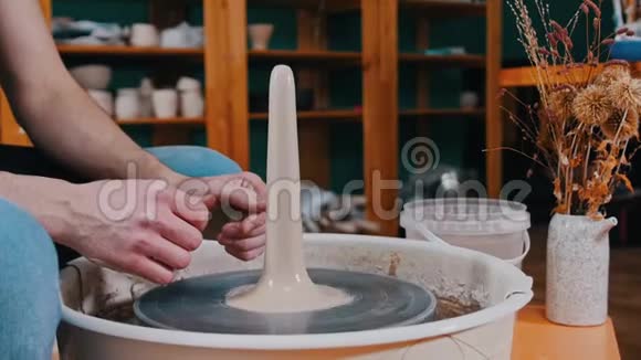 陶工在陶工的车轮上旋转一块较长形状的粘土视频的预览图
