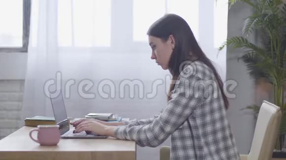 年轻的黑种人白种人女人在笔记本电脑键盘上打字时背部疼痛自信的女性自由职业者视频的预览图