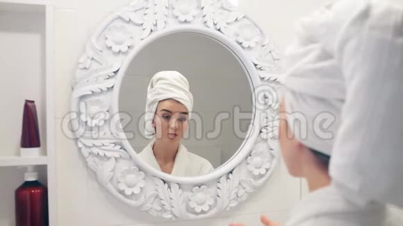 女人照镜子涂在脸上保湿霜视频的预览图