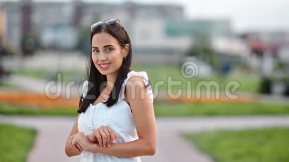 可爱的年轻性感少女穿着夏装微笑着摆着相机视频的预览图
