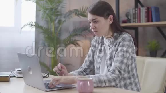愤怒的白人女孩在笔记本电脑键盘上打字的肖像愤怒的女性自由职业者在网上争论遥远的工作视频的预览图