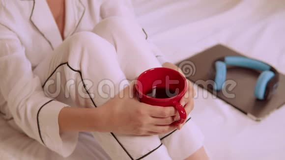 把穿白色睡衣的女人关在卧室里喝咖啡视频的预览图