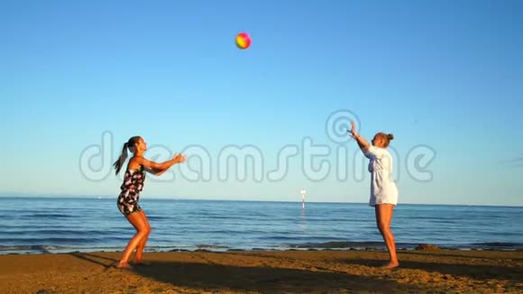 金发和黑发女孩在海边打排球视频的预览图