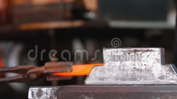 铁匠在锻压机器的压力下放置一块较长的白炽金属视频的预览图