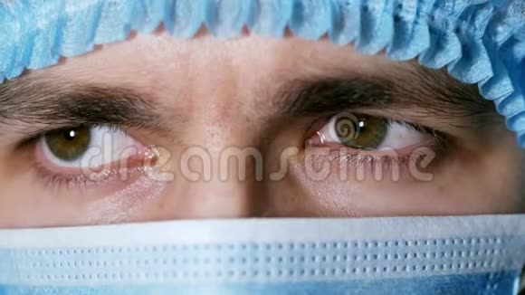 手术期间一位疲惫的男性医生闭上眼睛摘下面罩视频的预览图