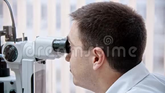 眼科医生一位眼科医生正在用一种特殊的仪器检查一位美女的视力视频的预览图