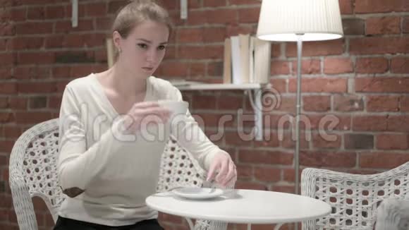 年轻貌美的女人喝咖啡思考视频的预览图